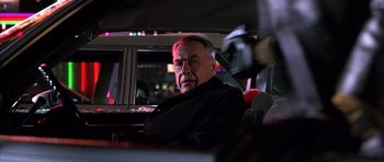 Movie still from “Hard Eight” (1996), directed by Paul Thomas Anderson – An older man sitting in the back seat of a car; Close Up shot, Over the shoulder angle