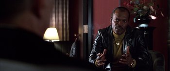 Movie still from “Hard Eight” (1996), directed by Paul Thomas Anderson – A man in a leather jacket is sitting in a room; Close Up shot, Over the shoulder angle