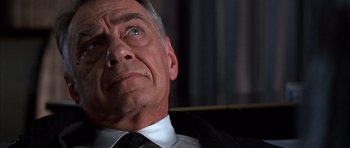 Movie still from “Hard Eight” (1996), directed by Paul Thomas Anderson – An older man wearing a suit and tie looking upward; Close Up shot, Low angle