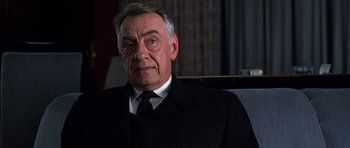 Movie still from “Hard Eight” (1996), directed by Paul Thomas Anderson – An older man wearing a black suit and tie; Close Up shot, Low angle