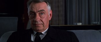 Movie still from “Hard Eight” (1996), directed by Paul Thomas Anderson – An older man wearing a suit and tie looking at the camera; Close Up shot, Low angle