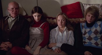 Movie still from “Hardcore” (1979), directed by Paul Schrader – Two young girls sitting on a couch looking at the camera; Medium shot, High angle