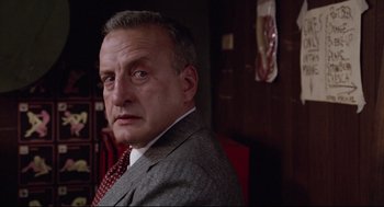 Movie still from “Hardcore” (1979), directed by Paul Schrader – A person wearing a suit and tie; Close Up shot, Low angle