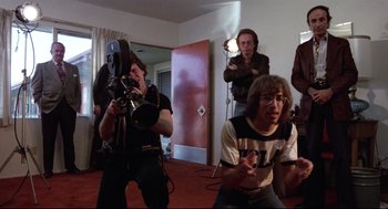 Movie still from “Hardcore” (1979), directed by Paul Schrader – A group of people in a living room playing a video game; Wide shot, Low angle