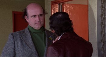 Movie still from “Hardcore” (1979), directed by Paul Schrader – A man with a bald head talking to another man; Close Up shot, Over the shoulder angle