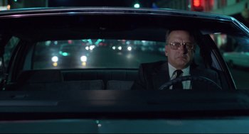 Movie still from “Hardcore” (1979), directed by Paul Schrader – A man sitting in the back seat of a car at night; Medium shot, Low angle