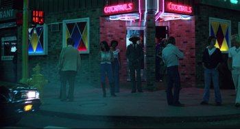 Movie still from “Hardcore” (1979), directed by Paul Schrader – A group of people standing in front of a building; Wide shot, High angle