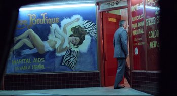 Movie still from “Hardcore” (1979), directed by Paul Schrader – A man in a business suit standing in front of a store; Wide shot, Low angle