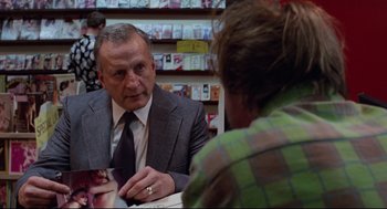 Movie still from “Hardcore” (1979), directed by Paul Schrader – An older man wearing a suit and tie talking to a woman in front of him; Close Up shot, Over the shoulder angle