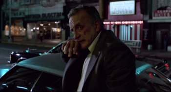 Movie still from “Hardcore” (1979), directed by Paul Schrader – An older man in a suit leaning on the side of a car; Medium shot, Low angle