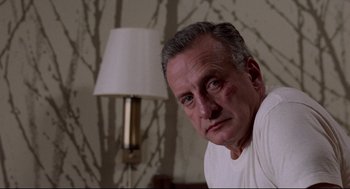 Movie still from “Hardcore” (1979), directed by Paul Schrader – A person in a white shirt near a lamp; Close Up shot, Low angle