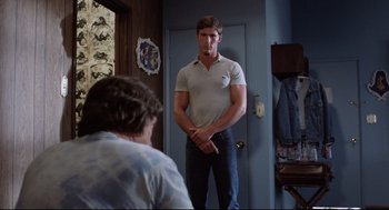 Movie still from “Hardcore” (1979), directed by Paul Schrader – A man standing in front of a mirror in a room; Medium shot, Over the shoulder angle