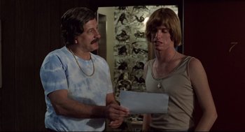 Movie still from “Hardcore” (1979), directed by Paul Schrader – Two men standing next to each other holding papers; Medium shot, Low angle