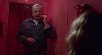 Movie still from “Hardcore” (1979), directed by Paul Schrader – A man is talking on a phone in a mirror; Medium shot, Low angle