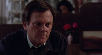 Movie still from “Hardcore” (1979), directed by Paul Schrader – A person sitting in a room; Close Up shot, Over the shoulder angle