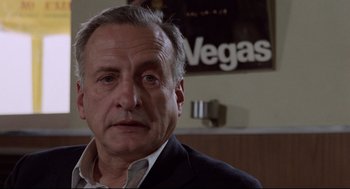 Movie still from “Hardcore” (1979), directed by Paul Schrader – An older man wearing a suit and tie in front of a vegas sign; Close Up shot, Low angle