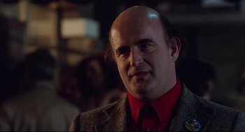 Movie still from “Hardcore” (1979), directed by Paul Schrader – A man with a bald head wearing a red shirt; Close Up shot, Over the shoulder angle