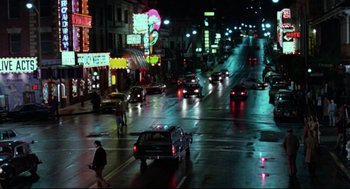 Movie still from “Hardcore” (1979), directed by Paul Schrader – A city street at night lit up by street lights; Extreme Wide shot, High angle
