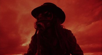 Movie still from “Hardware” (1990), directed by Richard Stanley – A person wearing a gas mask in the dark; Close Up shot, Low angle