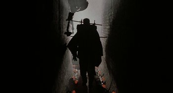 Movie still from “Hardware” (1990), directed by Richard Stanley – A man walking down a dark alley way; Wide shot, Low angle