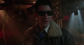 Movie still from “Hardware” (1990), directed by Richard Stanley – A man wearing sunglasses and wearing a jacket; Close Up shot, Low angle