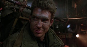 Movie still from “Hardware” (1990), directed by Richard Stanley – A person wearing a green jacket; Close Up shot, Low angle