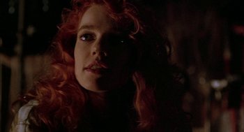 Movie still from “Hardware” (1990), directed by Richard Stanley – A person with long red curly hair; Close Up shot, Low angle