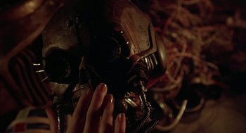 Movie still from “Hardware” (1990), directed by Richard Stanley – A person is touching the wires of a helmet; Extreme Close Up shot, Overhead angle