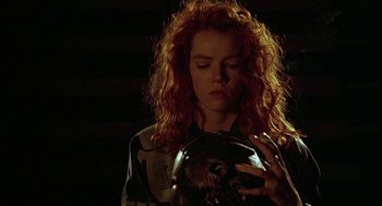 Movie still from “Hardware” (1990), directed by Richard Stanley – A woman with red curly hair looking at a crystal ball; Close Up shot, Low angle