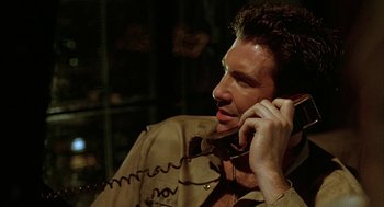 Movie still from “Hardware” (1990), directed by Richard Stanley – A person talking on a cell phone; Close Up shot, Low angle
