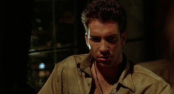 Movie still from “Hardware” (1990), directed by Richard Stanley – A person wearing a brown shirt; Close Up shot, Low angle