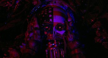 Movie still from “Hardware” (1990), directed by Richard Stanley – The face of an american robot; Close Up shot, Overhead angle