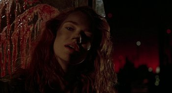 Movie still from “Hardware” (1990), directed by Richard Stanley – A woman with long red curly hair is posing for the camera; Close Up shot, Low angle