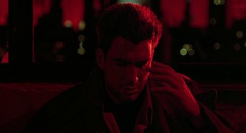 Movie still from “Hardware” (1990), directed by Richard Stanley – A man sitting in the dark with his hand on his head; Close Up shot, Over the shoulder angle