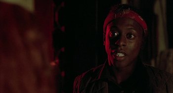 Movie still from “Hardware” (1990), directed by Richard Stanley – A young man with a red bandanna on his head; Close Up shot, Over the shoulder angle
