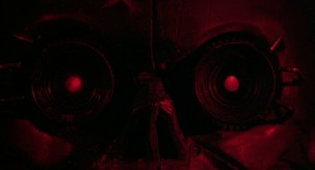Movie still from “Hardware” (1990), directed by Richard Stanley – View of two red lights in a room; Extreme Close Up shot, Overhead angle