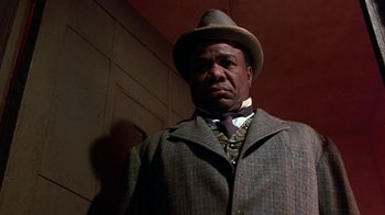 Movie still from “Harlem Nights” (1989), directed by Eddie Murphy – A man wearing a hat and a suit; Close Up shot, Low angle