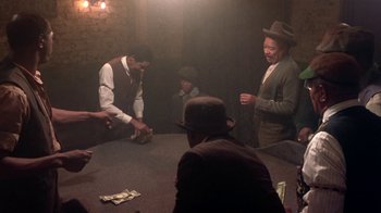 Movie still from “Harlem Nights” (1989), directed by Eddie Murphy – A group of men sitting around a table with money on it; Medium shot, High angle