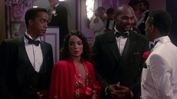 Movie still from “Harlem Nights” (1989), directed by Eddie Murphy – A group of people standing next to each other in a room; Medium shot, Over the shoulder angle