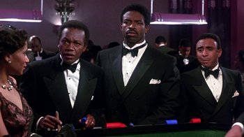 Movie still from “Harlem Nights” (1989), directed by Eddie Murphy – Two men in tuxedos standing next to a table; Medium shot, Low angle