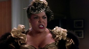 Movie still from “Harlem Nights” (1989), directed by Eddie Murphy – A woman in a gold dress and a black hat; Close Up shot, High angle