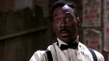 Movie still from “Harlem Nights” (1989), directed by Eddie Murphy – A person wearing a suit and tie; Close Up shot, Low angle