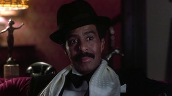 Movie still from “Harlem Nights” (1989), directed by Eddie Murphy – A person wearing a hat and a tie; Close Up shot, Low angle