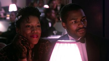 Movie still from “Harlem Nights” (1989), directed by Eddie Murphy – A man and a woman sitting next to each other; Close Up shot, Low angle