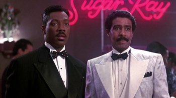 Movie still from “Harlem Nights” (1989), directed by Eddie Murphy – A couple of men standing next to each other in tuxedos; Medium shot, Low angle