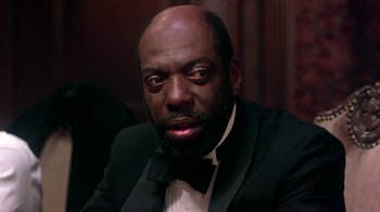 Movie still from “Harlem Nights” (1989), directed by Eddie Murphy – A man in a suit and bow tie; Close Up shot, Low angle