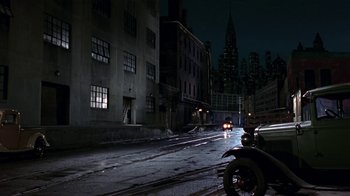 Movie still from “Harlem Nights” (1989), directed by Eddie Murphy – A motorcycle is parked on the side of the street; Extreme Wide shot, High angle