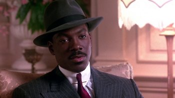Movie still from “Harlem Nights” (1989), directed by Eddie Murphy – A man wearing a suit and a hat; Close Up shot, High angle