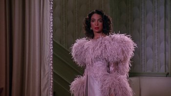 Movie still from “Harlem Nights” (1989), directed by Eddie Murphy – A woman in a pink dress standing in front of a mirror; Medium shot, Low angle