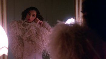 Movie still from “Harlem Nights” (1989), directed by Eddie Murphy – A woman in a white dress is looking in the mirror; Close Up shot, Low angle
